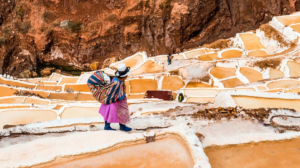 Terraced salt flats with people walking.