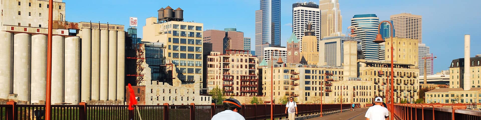 An adult man has special cargo in tow as he crosses the Stone Arch Bridge in Minneapolis