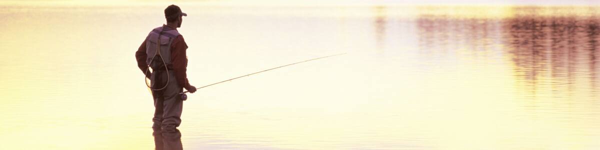 A fly-fisherman looks for feeding trout at sunrise.