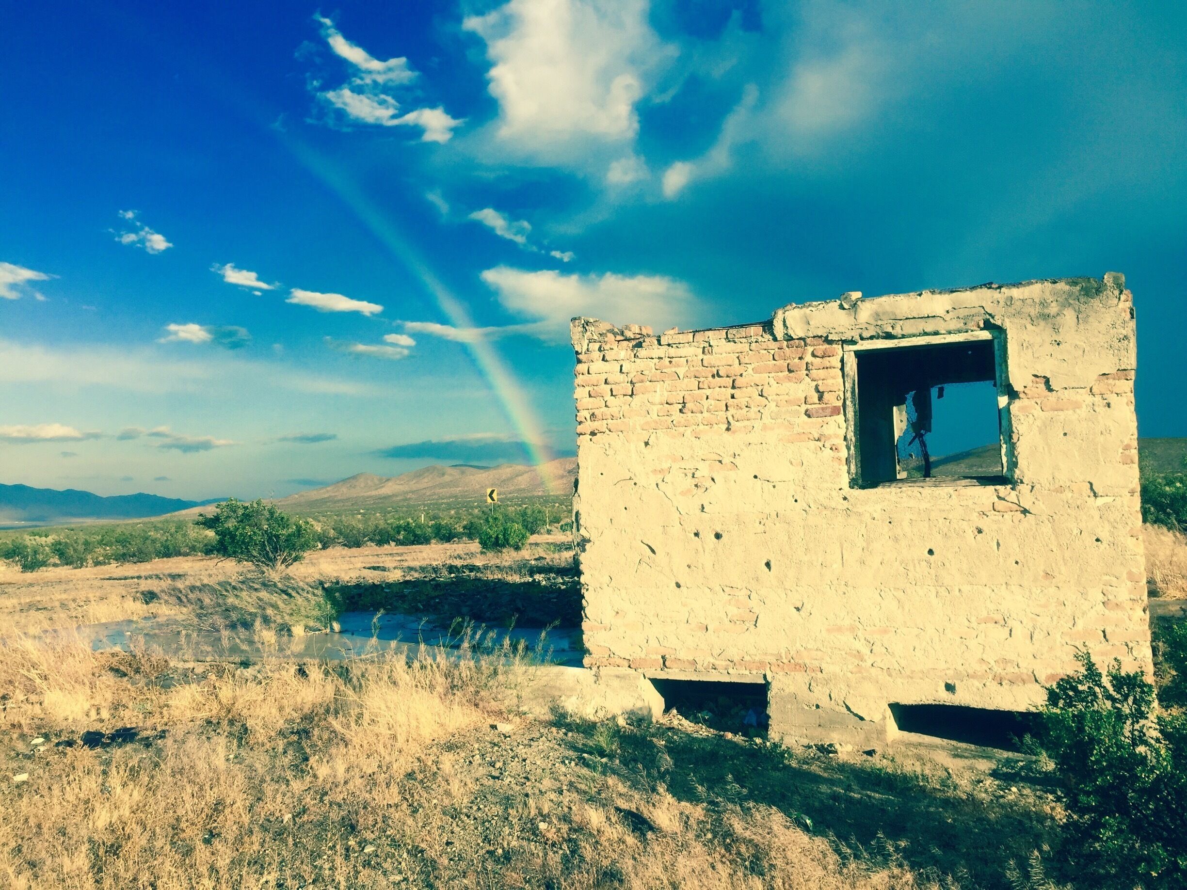 Some ruins on Historic Route 66, proceeding a desert rain storm. Notice the rainbow. 