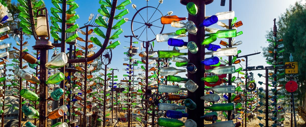 A sculpture garden with various installations made from recycled glass bottles.
