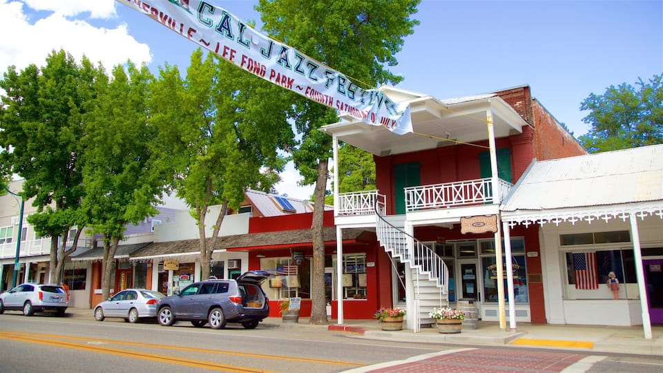 A street with a jazz festival banner, a building with a balcony, and a storefront with an American flag.