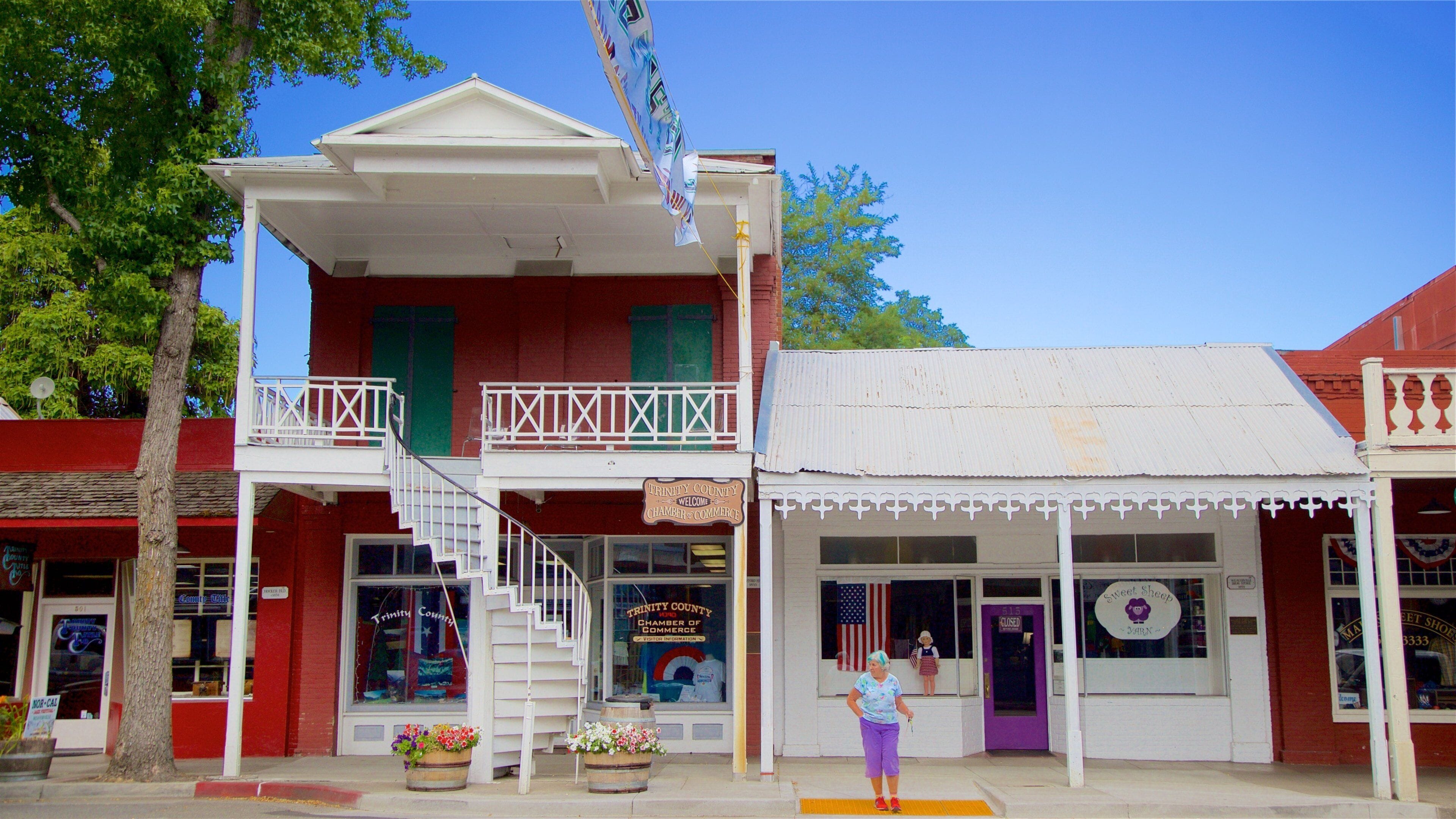 A historic building with a balcony and a sign that reads "Trinity County Welcome Chamber of Commerce".