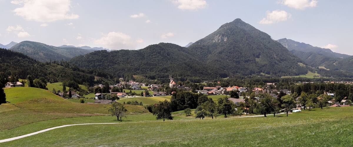 A village nestled in a valley with a prominent mountain in the background.