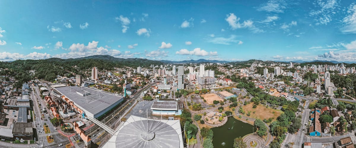 A cityscape with a large stadium, dense urban buildings, and surrounding greenery.