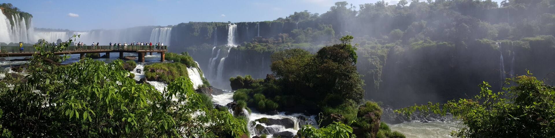 A large waterfall with multiple cascades surrounded by lush greenery and a viewing platform.