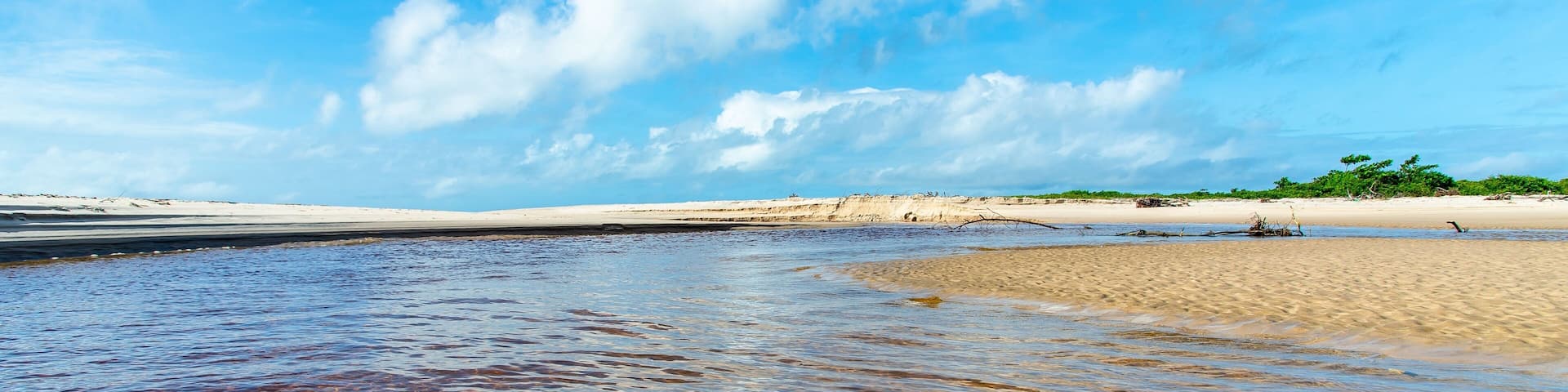 Reddish water of a river against the blue sky at Guaibim beach in Bahia, Brazil