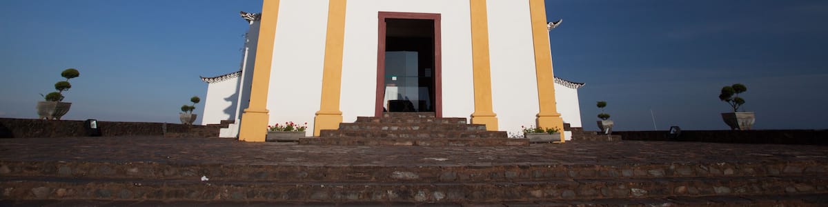 A church with two bell towers, a cross, and steps leading up to the entrance.