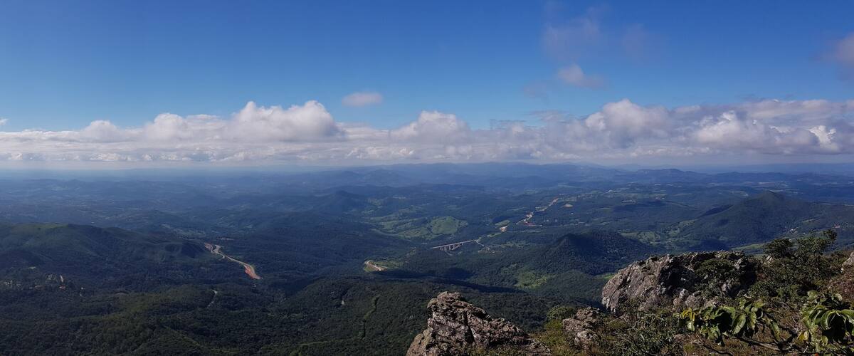 A mountainous landscape with a clear sky and scattered clouds.