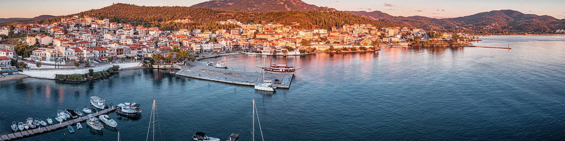 Aerial panorama of a scenic resort town Neos Marmaras with yacht marina sea port in Halkidiki, Sithonia. Majestic sunset time. Travel attractions and vacation in Greece