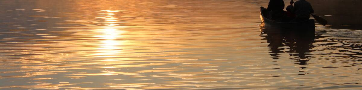 sunrise river silhouette in canoe