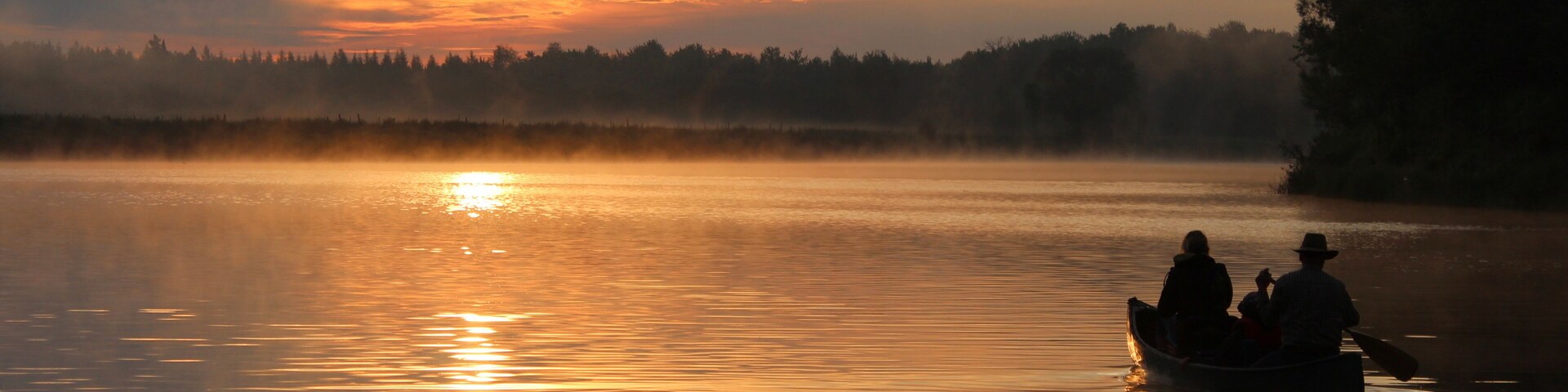 sunrise river silhouette in canoe