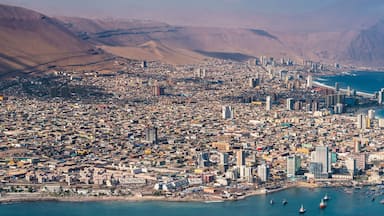 Una città costiera caratterizzata da un'intensa urbanizzazione, un'area portuale importante e montagne sullo sfondo.