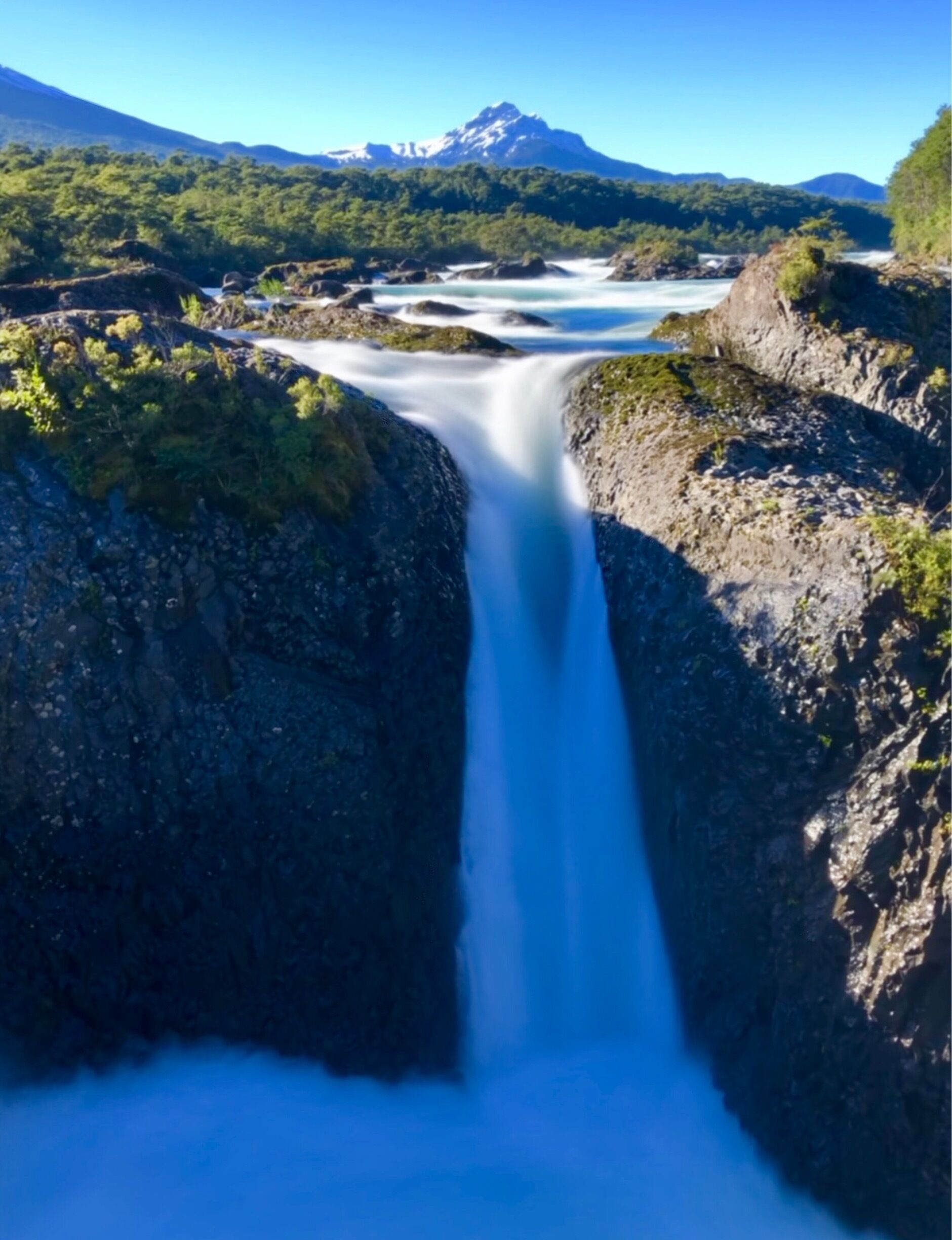 Waterfall with snow cap volcano behind