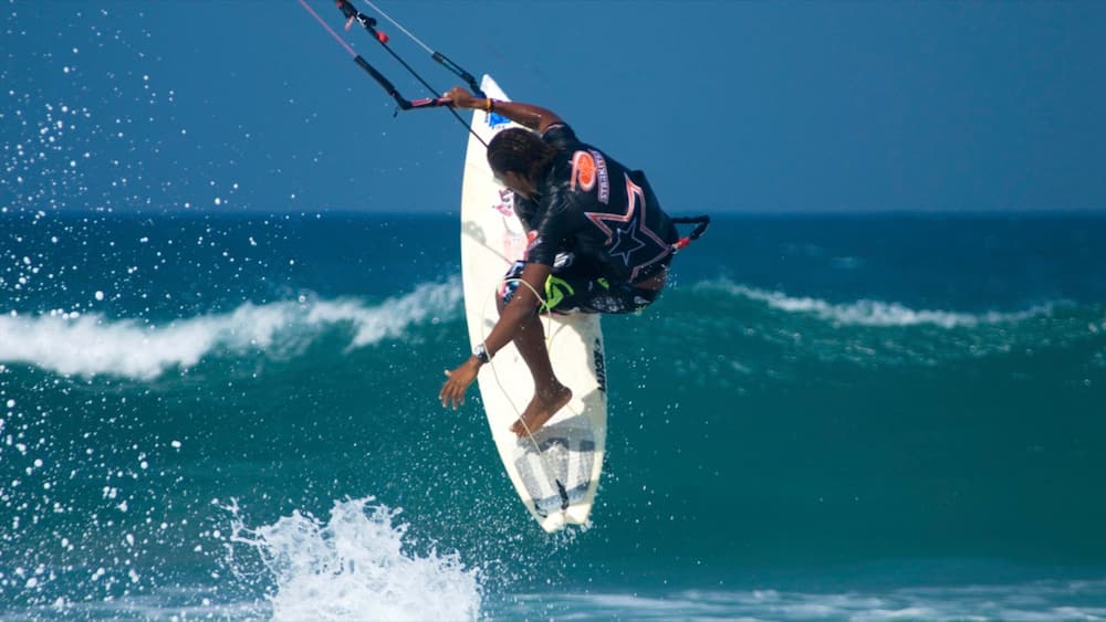 A person kiteboarding on a wave.