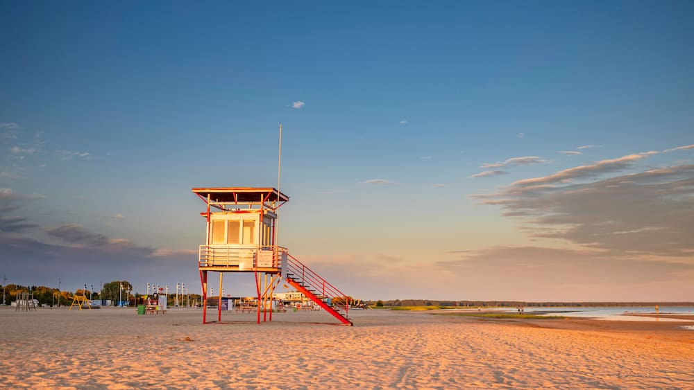 Parnu beach in Estonia during sunny summer sunset, life guard tower in foreground