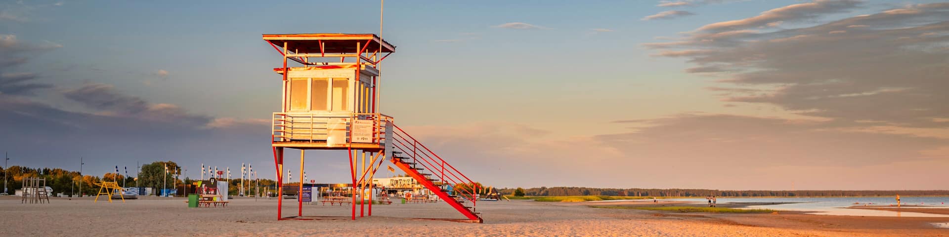 Parnu beach in Estonia during sunny summer sunset, life guard tower in foreground