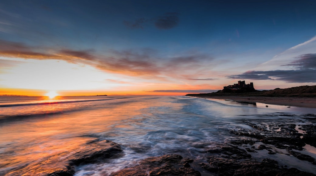 An early morning sunrise over the beach at Bamburgh Castle in Northumberland