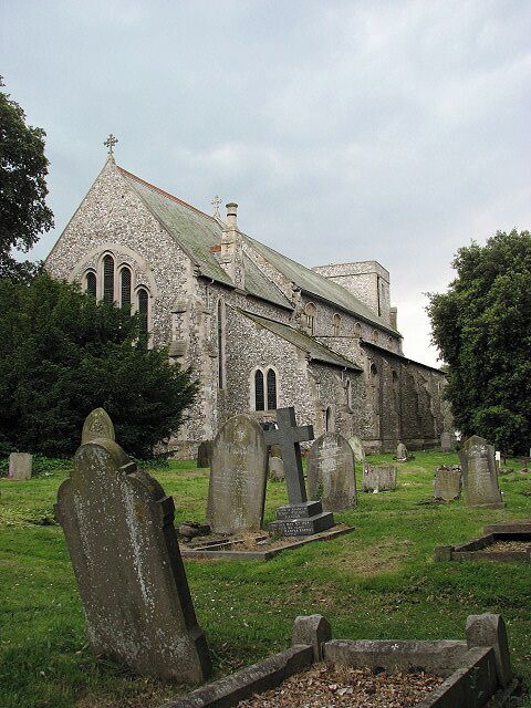 A historic church with a stone facade and multiple tombstones in the graveyard.