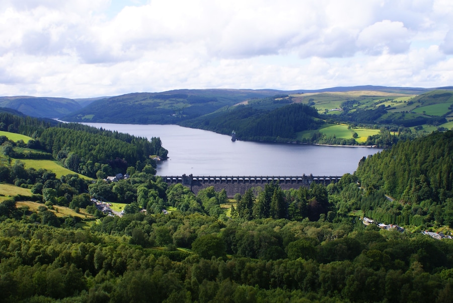 Lake Vyrnwy and Dam in Powys, Wales. From the summit of Craig garth-bwlch. Showing the village of Llanwddyn, much of the lake looking north west, the dam and the straining tower. This photo was taken on 25/07/09 at 16:23 by Sean Hattersley.