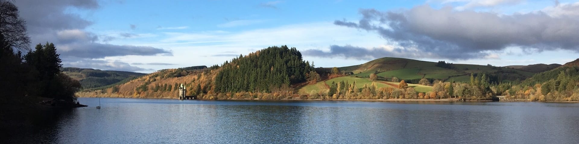 A lake surrounded by hills and trees.