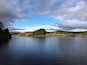 A lake surrounded by hills and trees.