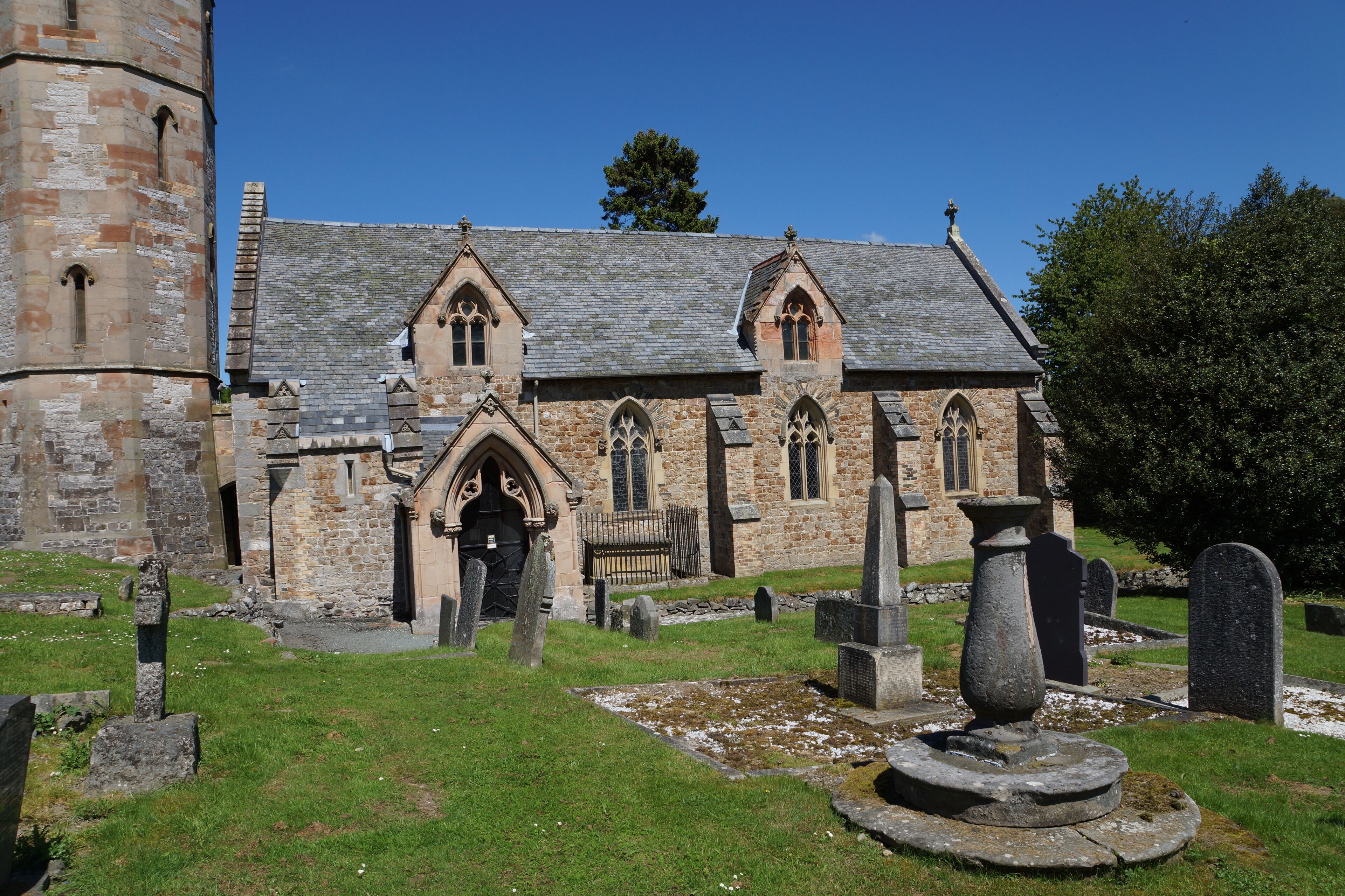 Nave and base of the west tower of parish church of St Michael the Archangel, Llanyblodwel, Shropshire, England. The sundial in the foreground was made in 1712.