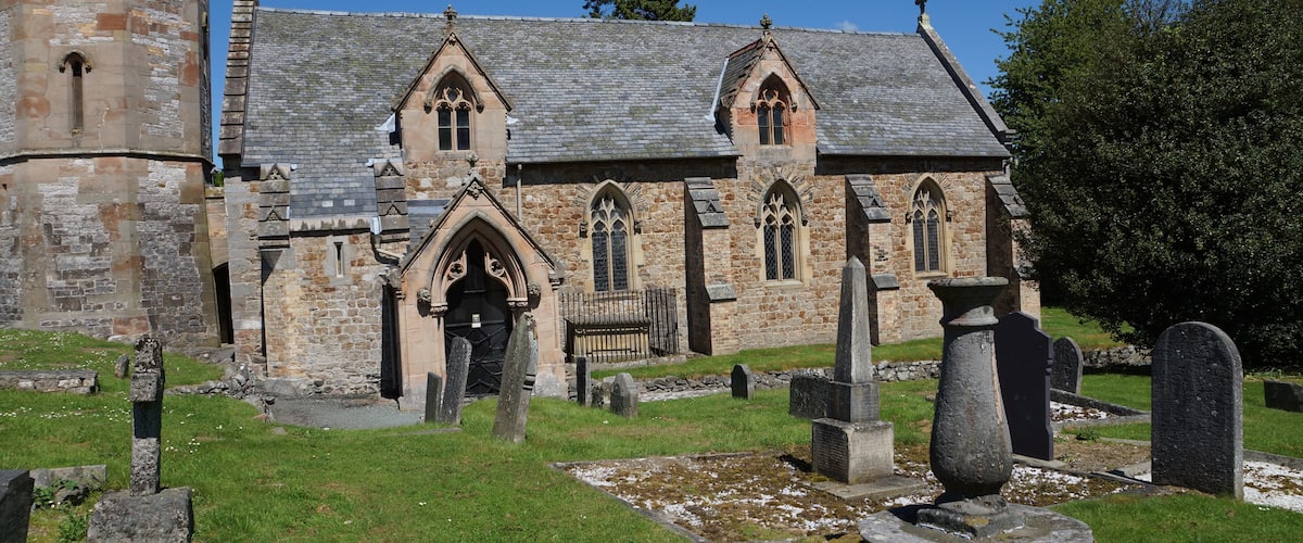 Nave and base of the west tower of parish church of St Michael the Archangel, Llanyblodwel, Shropshire, England. The sundial in the foreground was made in 1712.