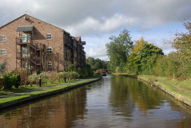 Lion Quays, Llangollen Canal. The building on the left of the canal is a modern hotel complex, with extensive visitor moorings, built to give the vague appearance of an old canal warehouse. This is approaching Moreton Bridge where the A5 crosses the canal.