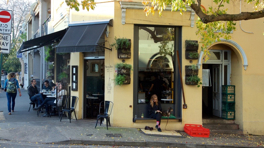 A café with outdoor seating, a 'No Entry' sign, and a 'One Way' sign on the street.