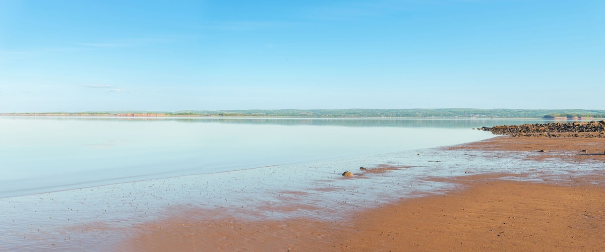 A calm beach with a clear sky.
