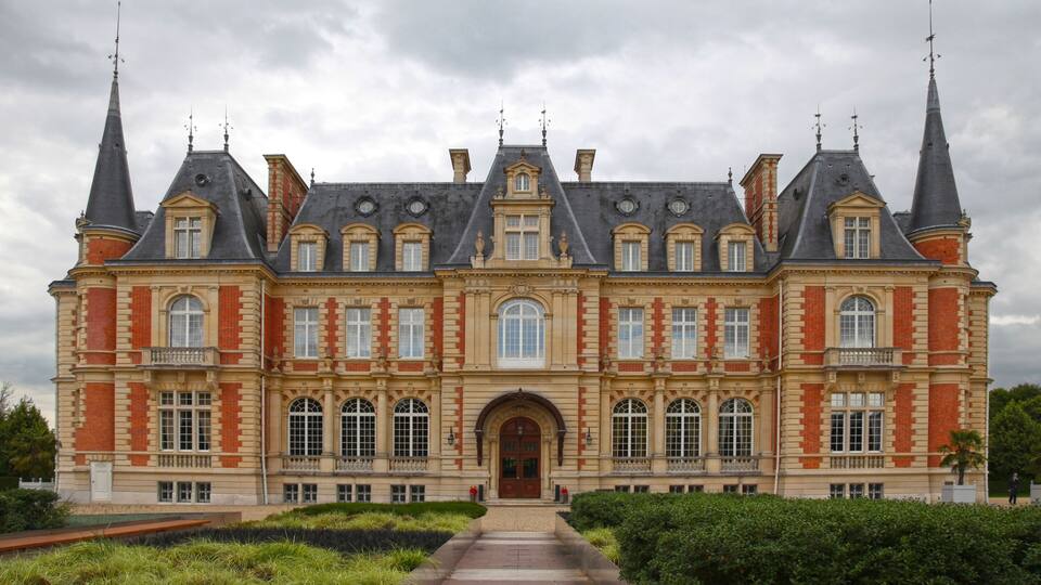 A large, historic building with multiple towers and a central entrance.