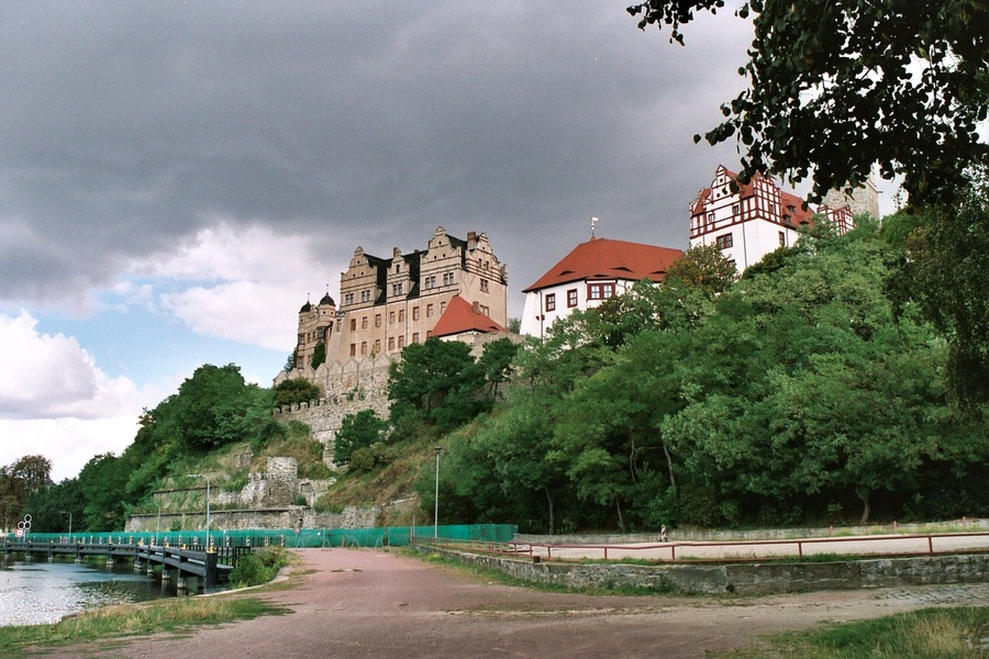 A castle on a hill with a bridge over a river.