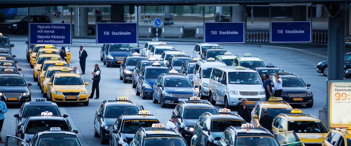 A busy traffic jam at an airport with multiple taxis and cars.