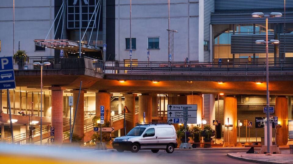 A terminal building with a sign reading 'Terminal 2' and a white van parked in front.