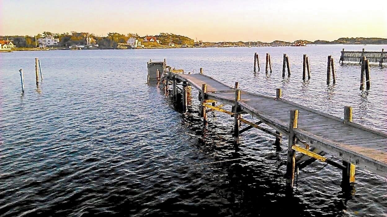 Billdal´s bathing site (Billdalsbadet) looking towards "Killingsholmen".

Photo taken an evening in April, and the badly storm damaged boat jetties have yet to be repaired...