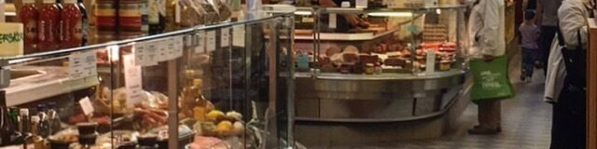 A food market with a deli counter and various food items on display.
