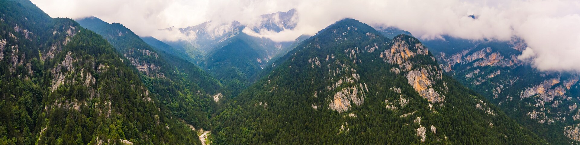 Leptokaria, Greece. Stunning aerial drone view of naturally beautiful Olympus Oros from Enipeas Waterfall. Clouded sky. Mountains and forests. High quality photo
