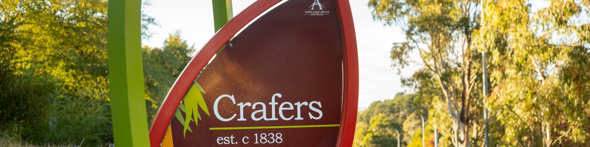 A sign with a koala and the text 'Crafers est. c 1838' along a roadside.