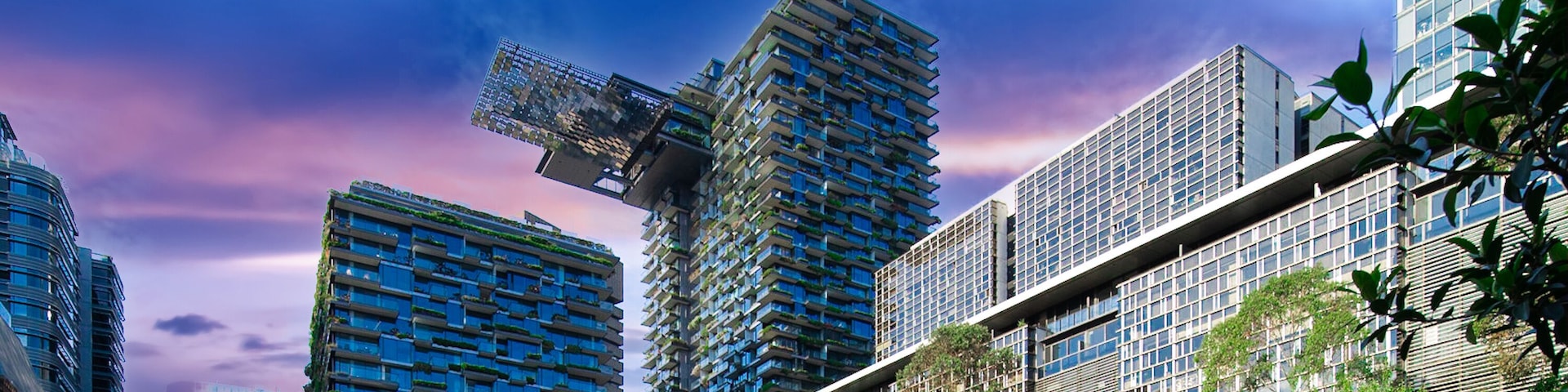 A modern urban park with green spaces, a unique circular sculpture, and contemporary high-rise buildings.