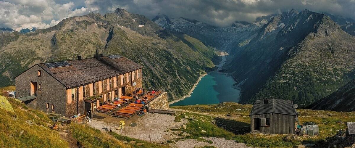 August 2018
Olperer Huette, Zillertal Alps, Austria
Olperer Huette is a mountain cabin with a spectacular view of some 700 meters over Schlegeisspeicher dam lake. It is located in 2.388 meters altitude on the south side of Tuxer Kamm range which is parallel to the main Zillertal range on the border of Austria and Italy (in the picture it is the range in the background covered with low clouds). The hut offers some 70 beds to tourists who can access it either from the lake bellow or the neighbouring huts. Olperer hut was built in 1881 and it was totally reconstructed to its modern look in 2007. It is also one of the huts on the famous trekking routes called Berliner Hoehenweg or Peter Habeler Runde.