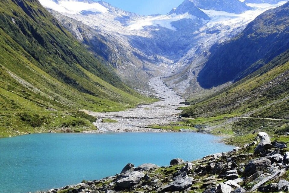 A mountain lake surrounded by rocky terrain and snow-capped peaks.