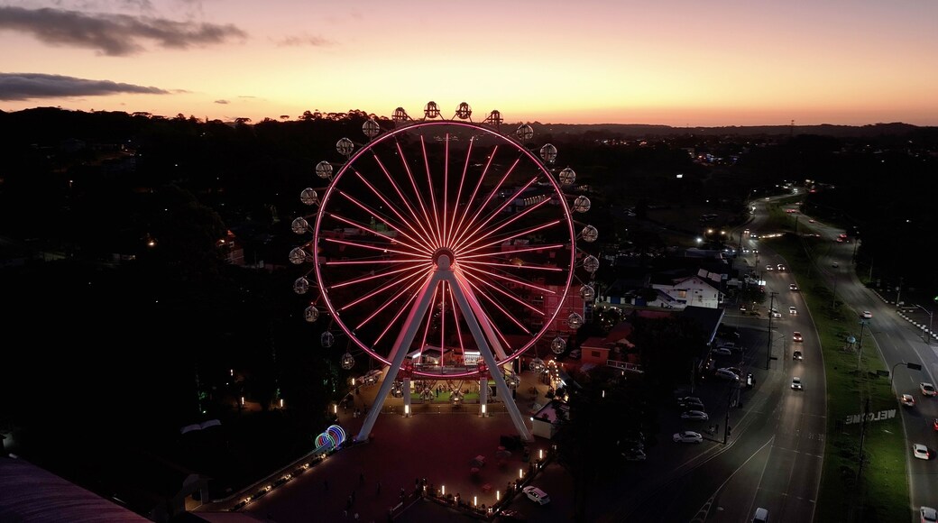 Illuminated Ferris Wheel At Canela In Rio Grande Do Sul Brazil. Colorful Ferris Wheel. Illuminated City. Sunset Landscape. Illuminated Ferris Wheel At Canela In Rio Grande Do Sul Brazil.