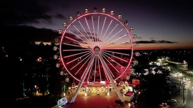 Illuminated Ferris Wheel At Canela In Rio Grande Do Sul Brazil. Colorful Ferris Wheel. Illuminated City. Sunset Landscape. Illuminated Ferris Wheel At Canela In Rio Grande Do Sul Brazil.