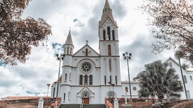 A white church with a tall steeple and a large circular window.