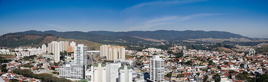 Un paisaje urbano con rascacielos y montañas al fondo.