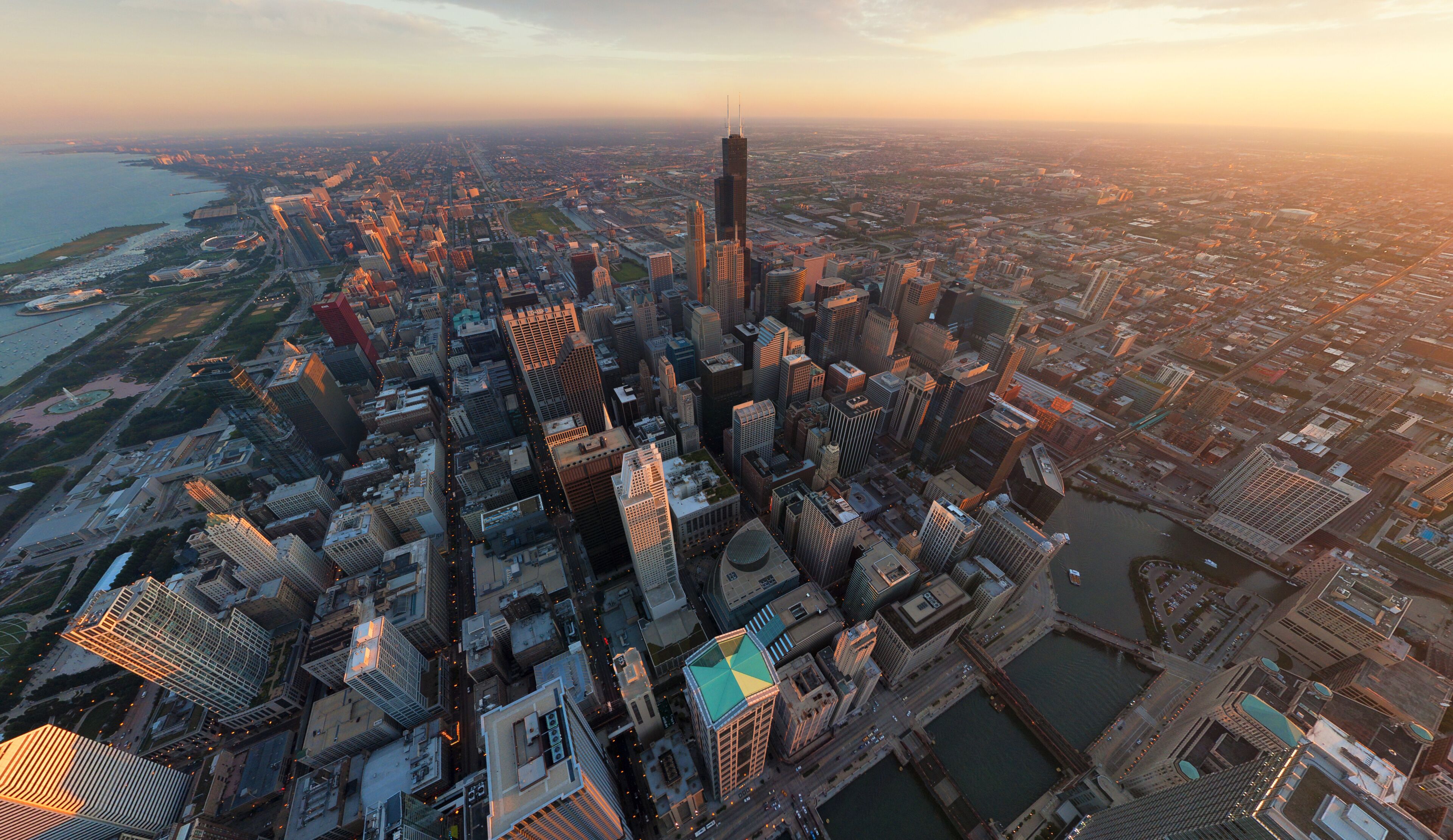 A cityscape with a prominent skyscraper, dense urban buildings, and a river.