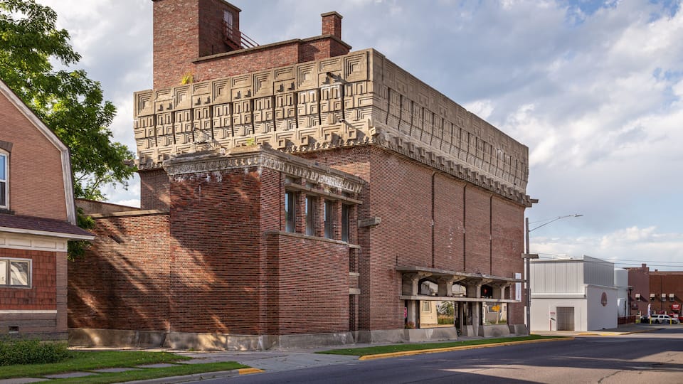 A historic brick building with intricate facade patterns and a flat roof.