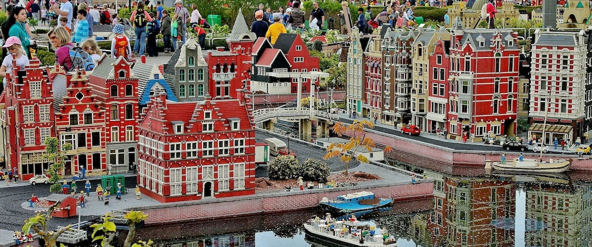 A model of a Dutch town with red and white buildings, a canal, and a small boat.