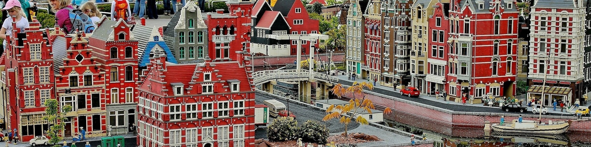 A model of a Dutch town with red and white buildings, a canal, and a small boat.